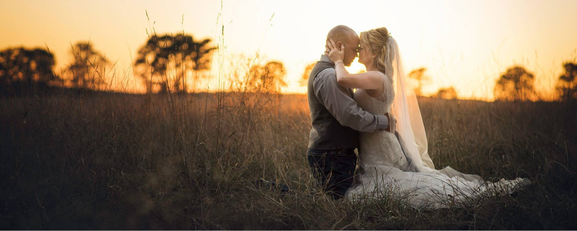 bride and groom embracing at sunset
